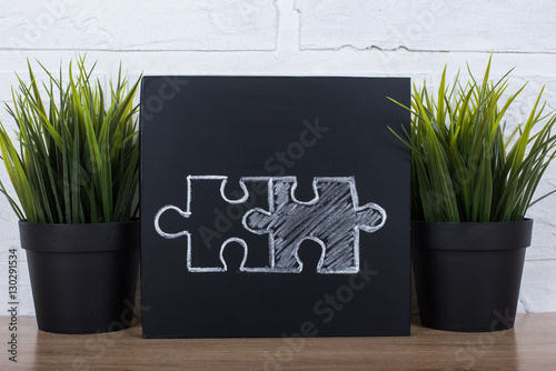 drawing with chalk on a blackboard two matching puzzle pieces photo