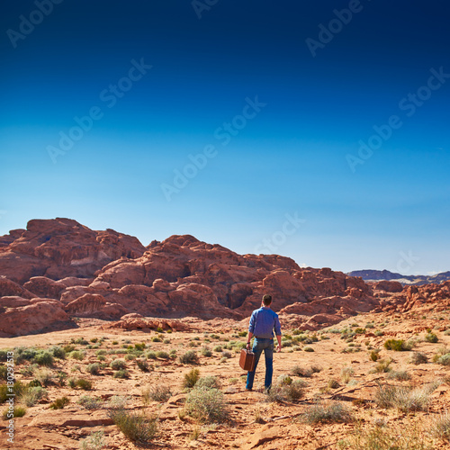 lone man with suitcase standing in desert alone © Joshua Resnick