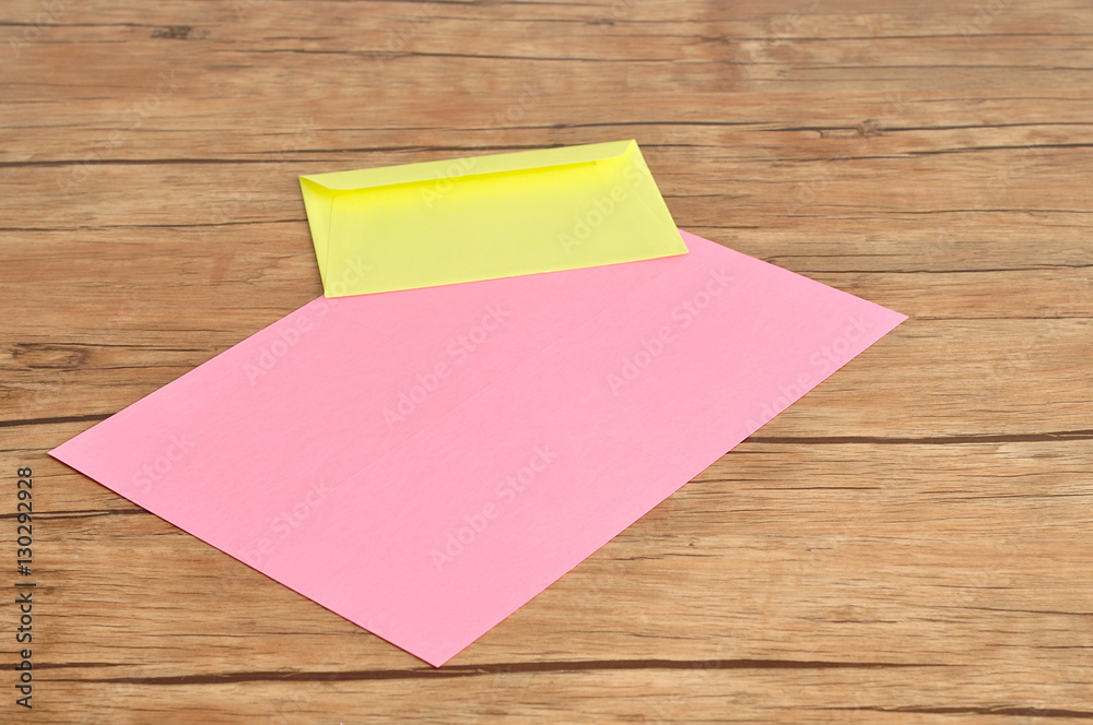 A pink paper and a yellow envelope