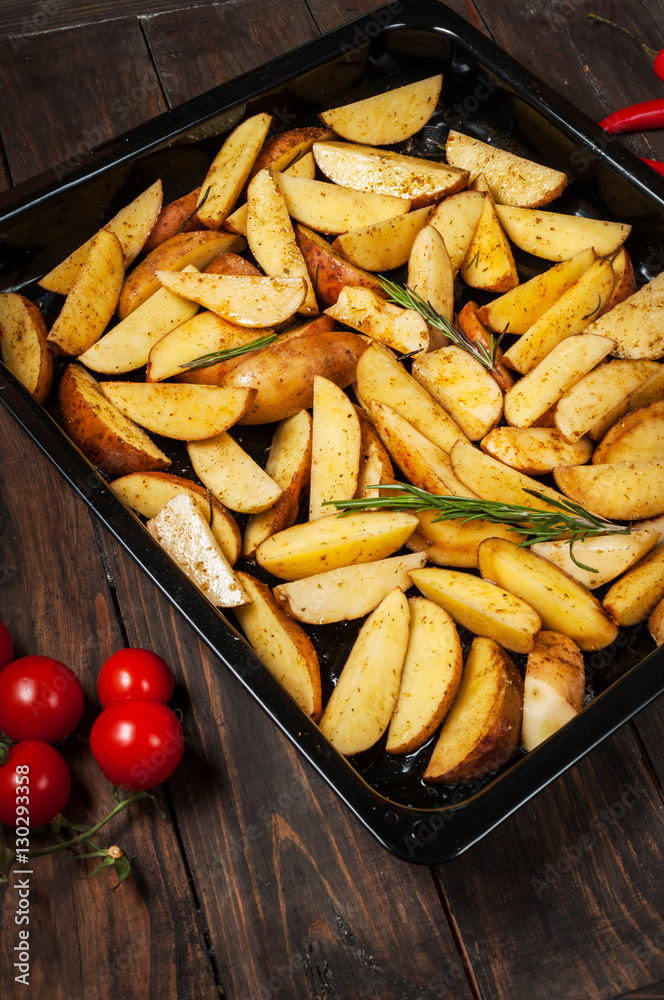 Uncooked potato wedges with rosemary and pepper