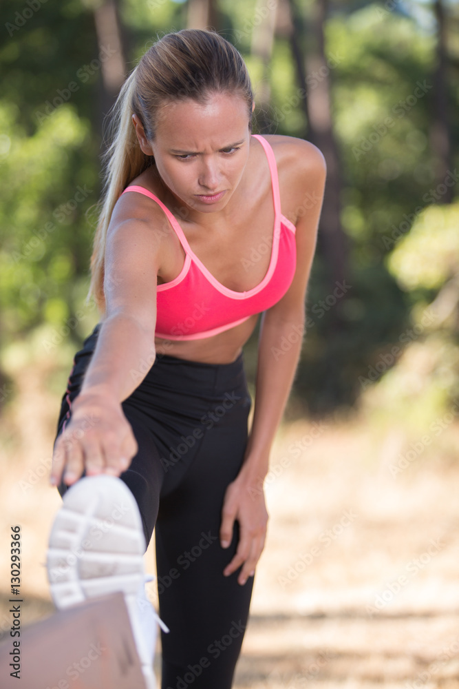 athletic woman stretching he legs before workout outside athletic woman stretching he legs before workout outside