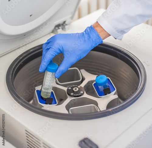 Technician loading a sample to centrifuge machine