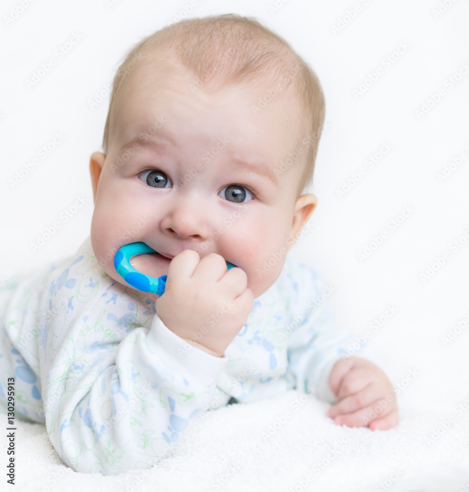 painful teething in infants, baby close-up with a toy. painful teething in infants, baby close-up with a toy.