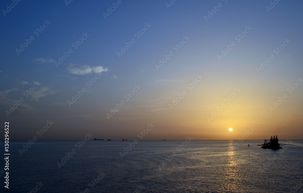 Fototapeta premium calm ocean sunset with boats