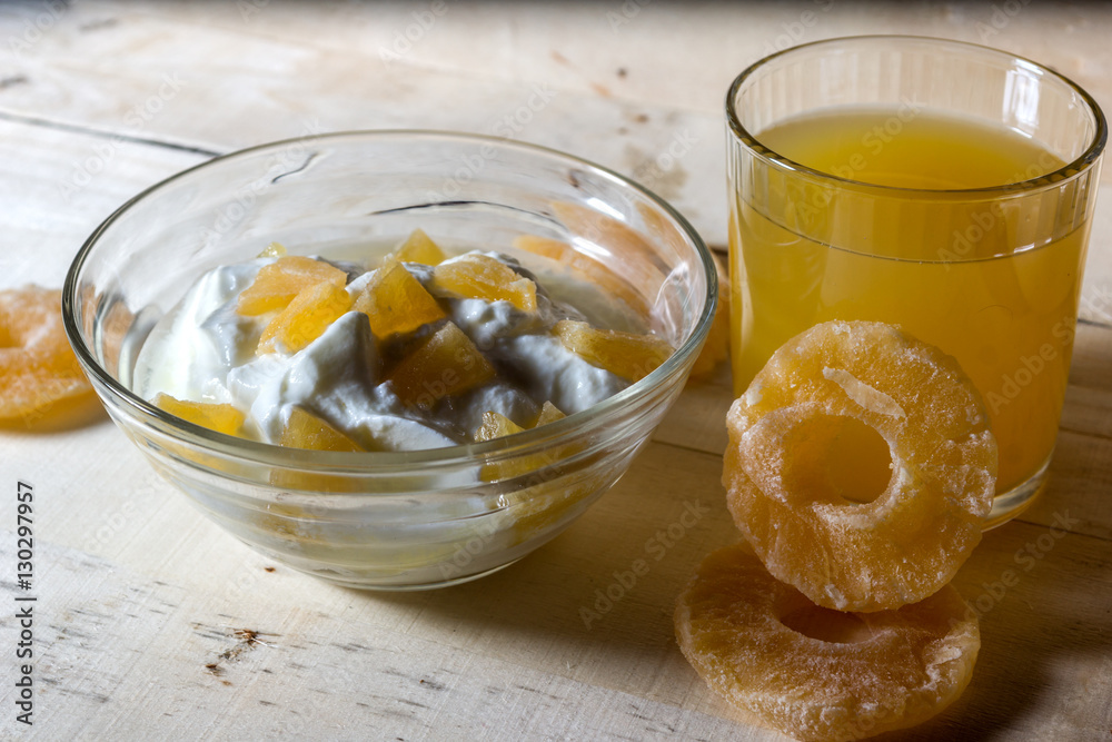 Breakfast with Yogurt with pieces of pineapple and orange juice on a wooden background Breakfast with Yogurt with pieces of pineapple and orange juice on a wooden background