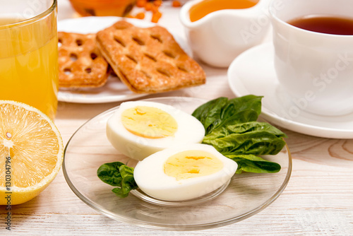 Healthy organic breakfast. Boiled eggs, cup of tea, orange juice