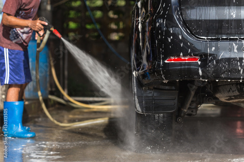 A man spraying pressure washer for car wash in car care shop
