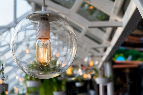 Beautiful vintage light bulb hanging down under the outdoor sun roof. © thaiprayboy