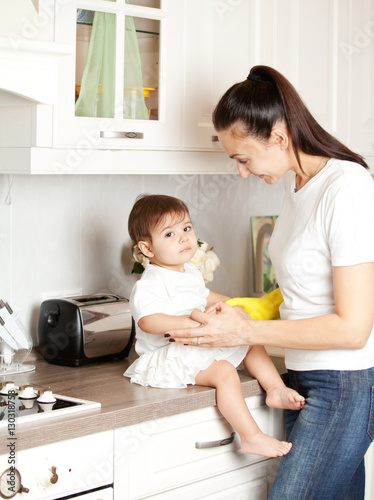 mom is busy in the kitchen with the child