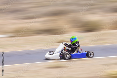 Fototapeta Naklejka Na Ścianę i Meble -  Youth Go Kart Racer on Track Panning Shot