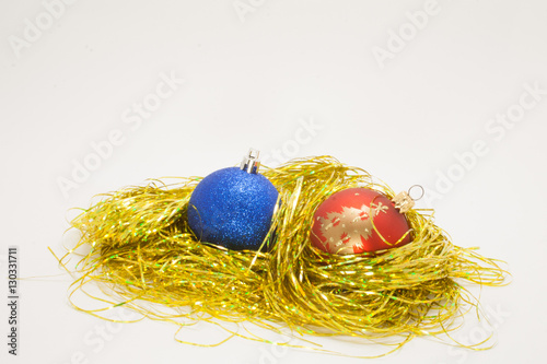 blue and red Christmas balls on the gold tinsel isolated on white background