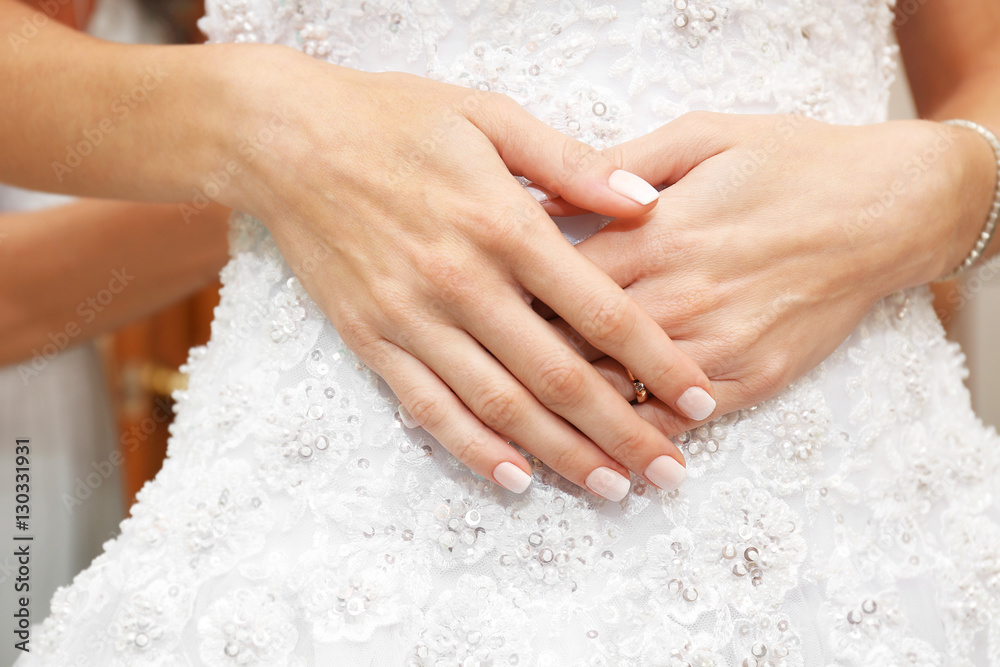 Hands of bride on beautiful wedding dress, closeup Hands of bride on beautiful wedding dress, closeup