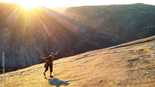 Female climber topping out of Snake Dike at sunset, Half Dome, Yosemite