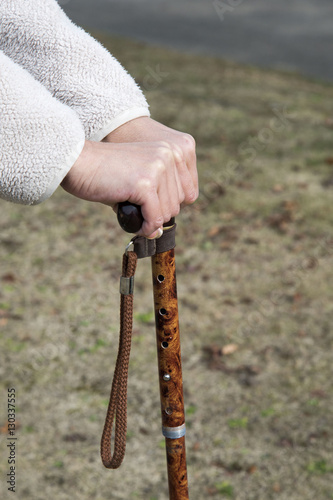 杖をつくシニア女性の散歩中の手元