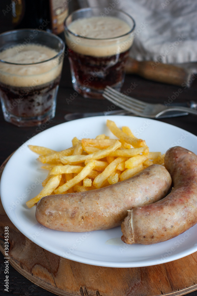 Sausages and potatoes with dark beer on a wooden table, selective focus Sausages and potatoes with dark beer on a wooden table, selective focus
