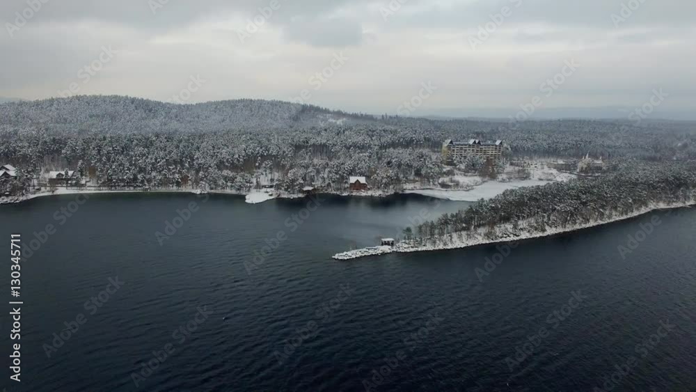 aerial spinning view of woods near lake at winter