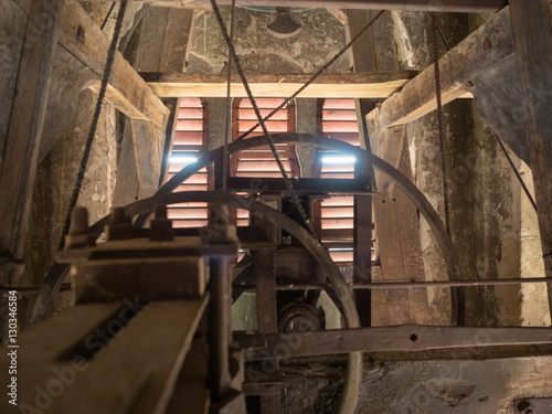 Slika na platnu Picture of the rusty mechanism in the wooden belfry of the church