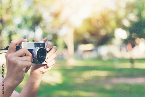 vintage autumn photo with girl standing in a park with old camera.