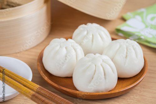 Steamed buns on wooden plate and bamboo steamer basket