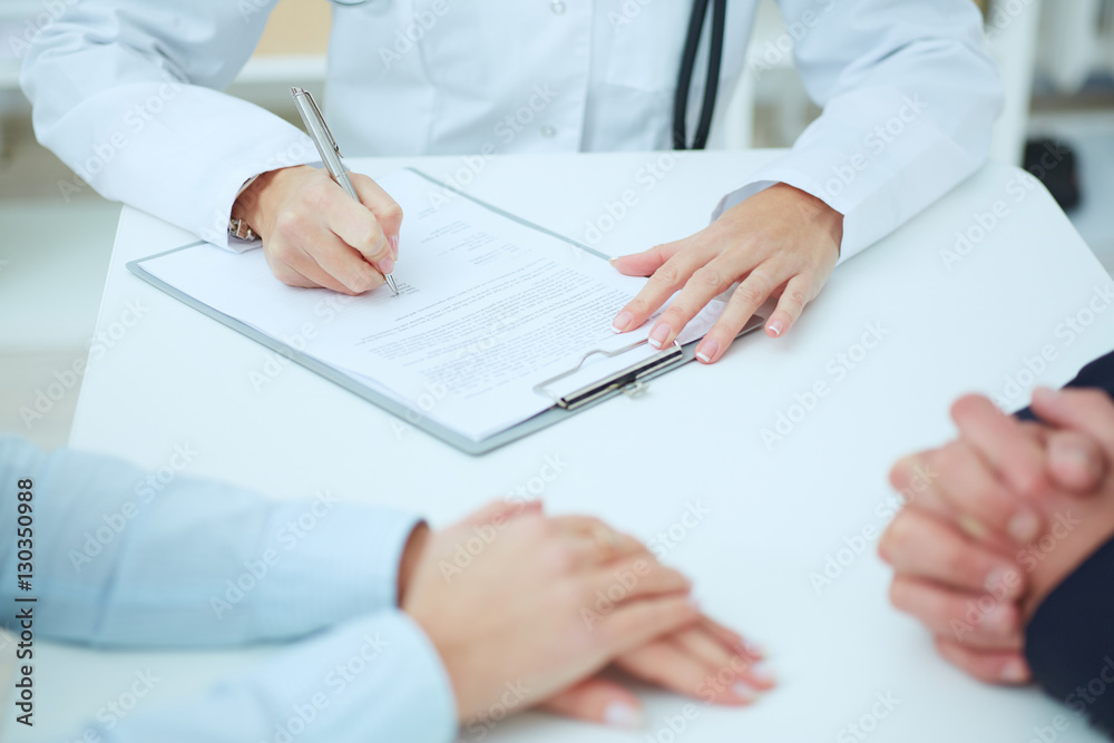 Closeup of patients hands and doctor taking notes. Ward round, patient visit check, medical calculation and statistics concept. Physician ready to examine patient
