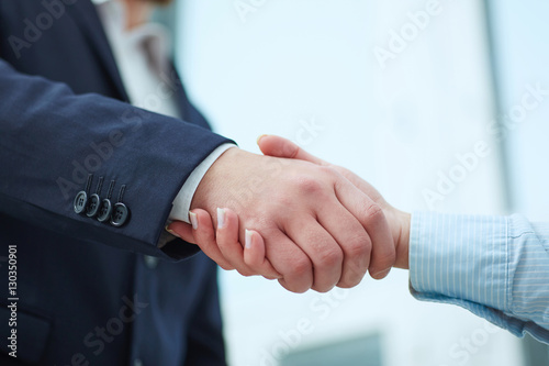 Closeup of male and female handshake in office.