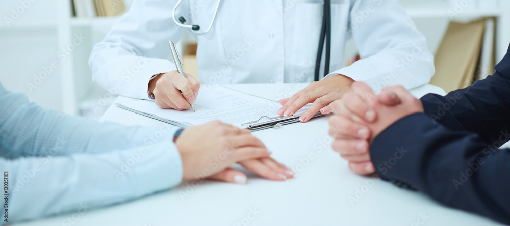 Closeup of patients hands and doctor taking notes. Physician ready to examine patient. Closeup of patients hands and doctor taking notes. Physician ready to examine patient.
