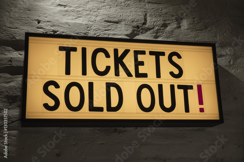 Close-up of Tickets Sold Out signboard against gray wall photo