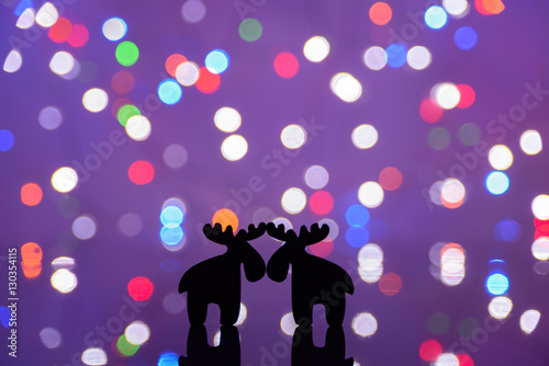 Christmas greeting card with cute reindeer silhouettes over a soft focus light background with copy space