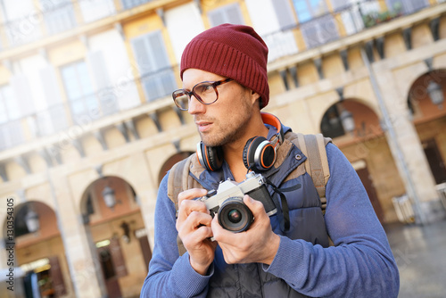 Hipster guy taking pictures in european city