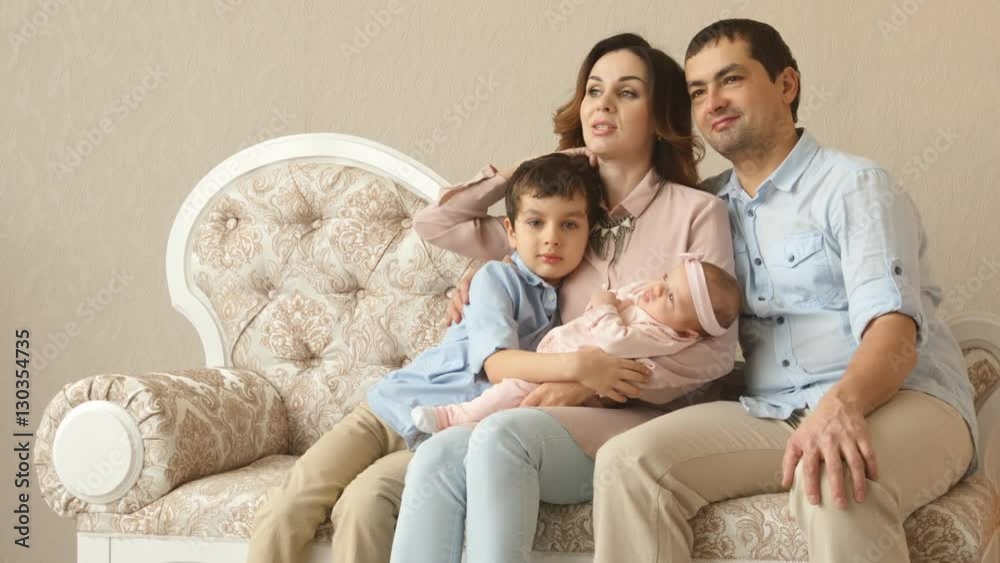 Young adult parents with their little son and infant in a studio Young adult parents with their little son and infant in a studio