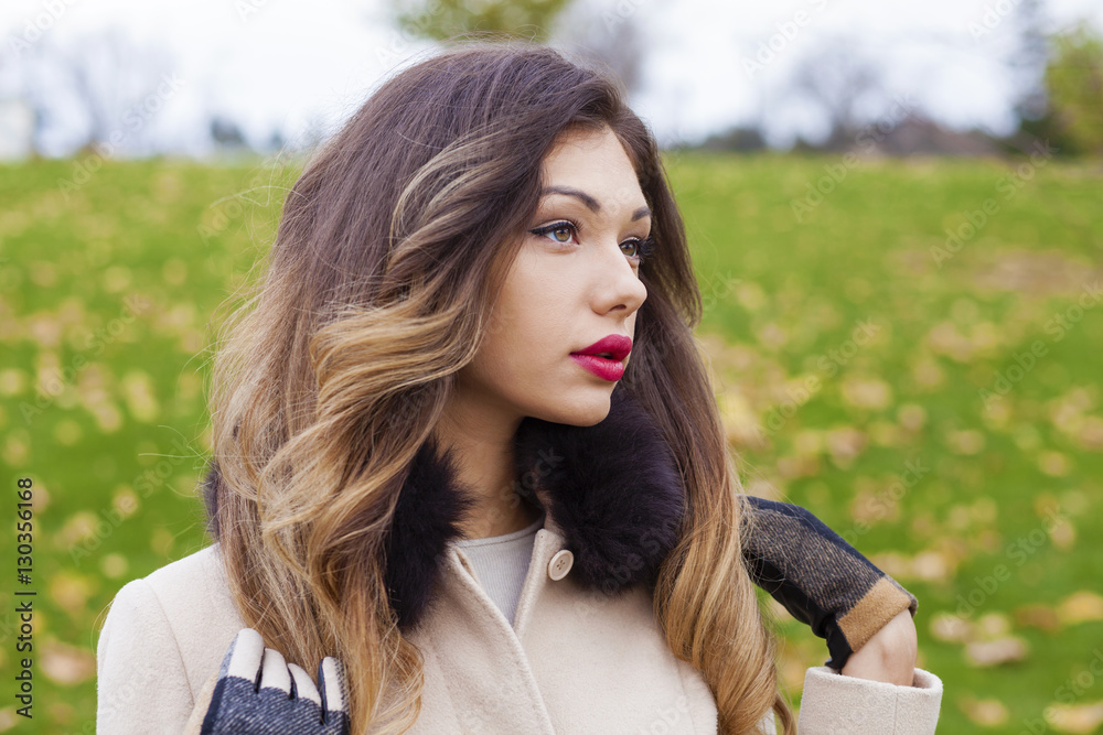 Portrait of a young beautiful woman in beige coat