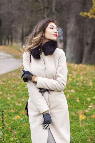 Portrait of a young beautiful woman in beige coat