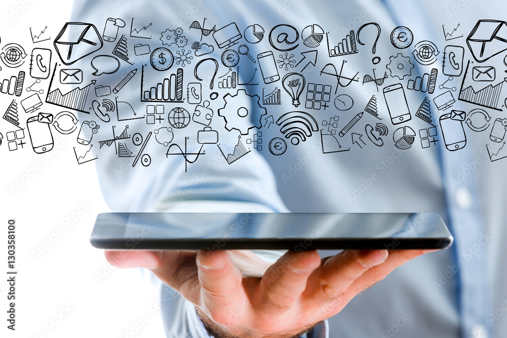 Hand of a man holding tablet with business icons all around Hand of a man holding tablet with business icons all around