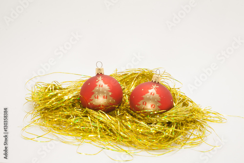 red Christmas balls on the gold tinsel isolated on white background