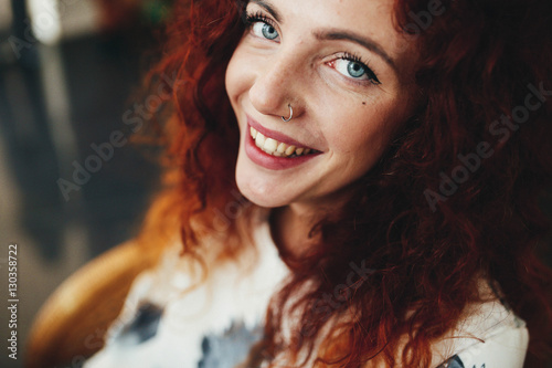beautiful young woman with red curly hair looking and smiling