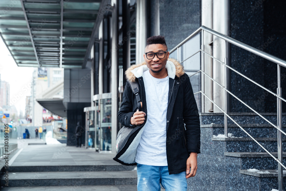 Young african man wearing backpack walking on the street Young african man wearing backpack walking on the street
