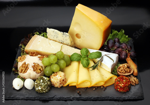 Cheese platter with different cheese and grapes - some emmental, gauda, parmesan and brie  cheese on a table for brunch photo