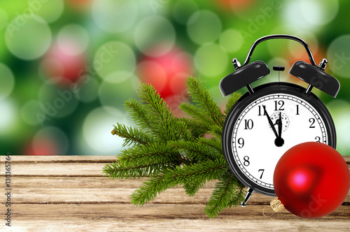 Christmas holiday background with alarm clock and tree branch on