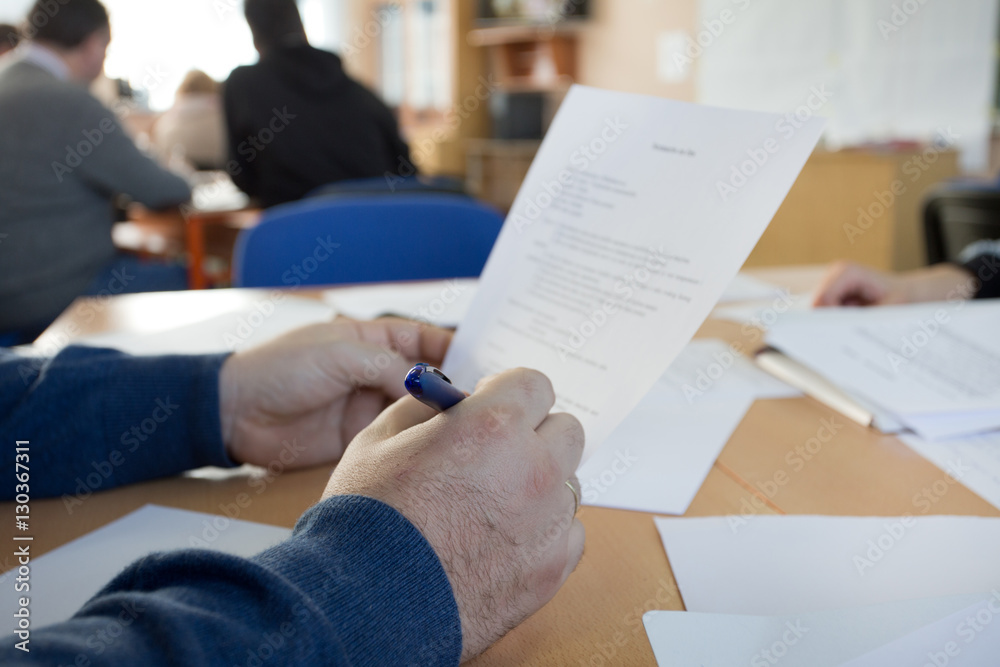Man reading paper at workshop Man reading paper at workshop