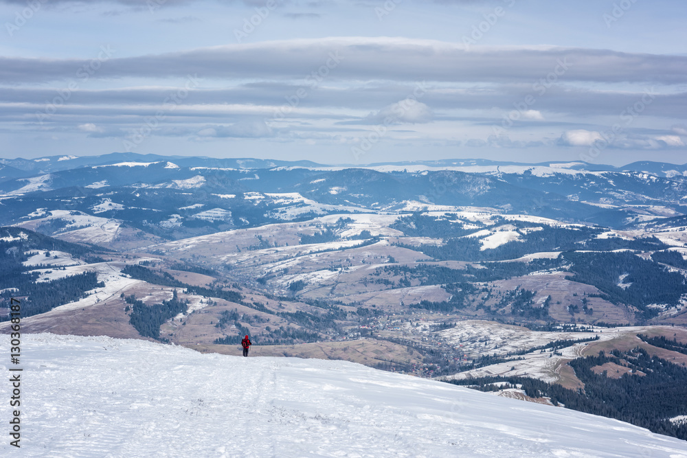 Mountain winter landscape with traveler enjoying beautiful view