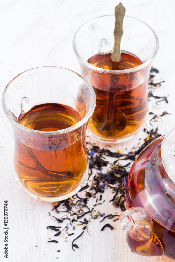cup of tea, tea leaves and tea pot on a white background cup of tea, tea leaves and tea pot on a white background