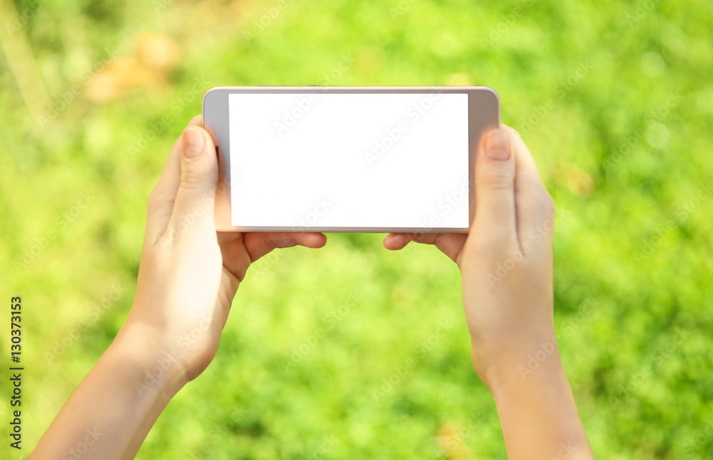 Woman holding modern cellphone, outdoor