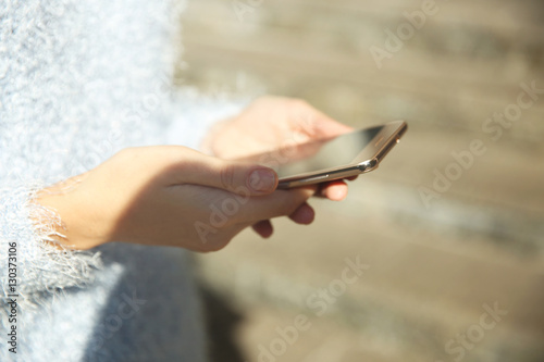 Woman holding modern cellphone  outdoor