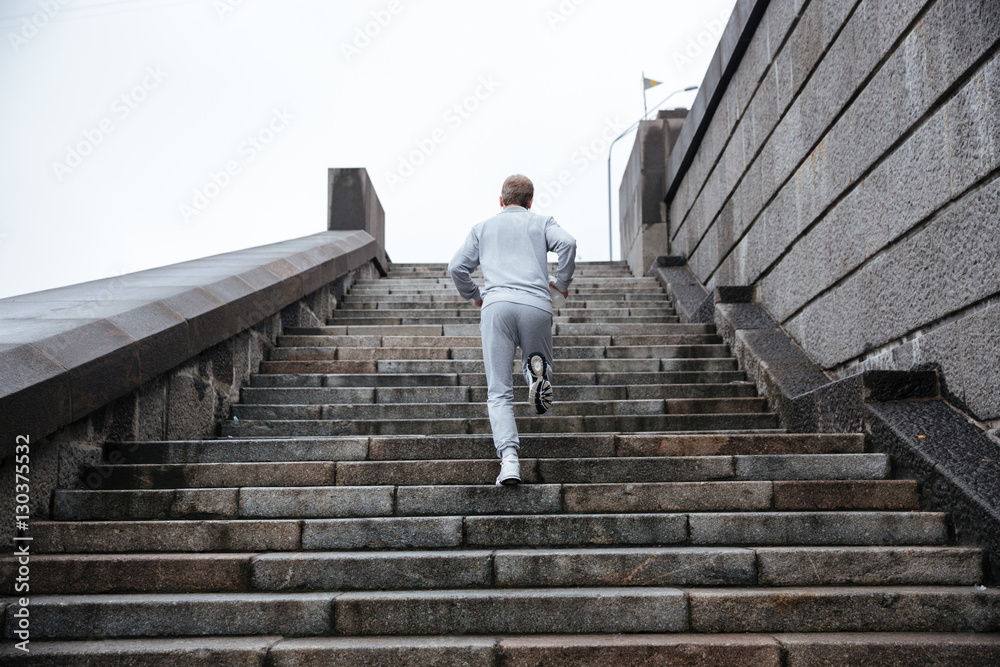 Back view of runner running on stairs