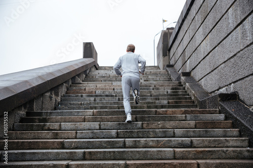 Back view of runner running on stairs