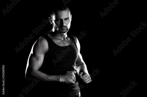 muscular man, clasps hands in fist, black and white toning