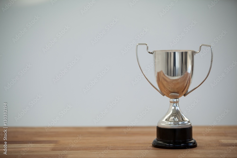 Silver trophy on wooden table Silver trophy on wooden table