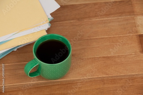 Files and coffee mug on wooden desk