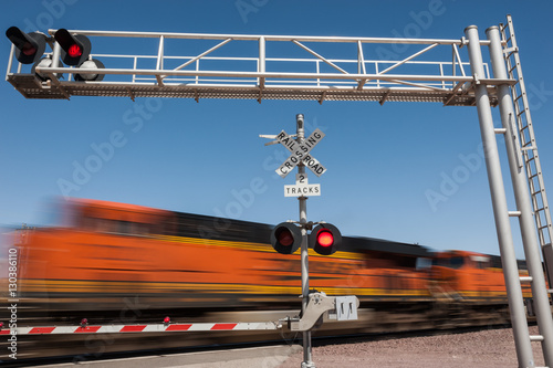 Zooming train engine speeding past railroad crossing