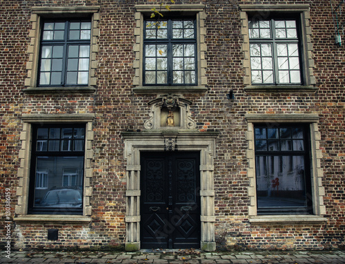 Door and windows on the brick wall of the house in Bruges, Belgium